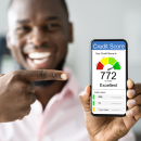 Man pointing at phone showing excellent credit score